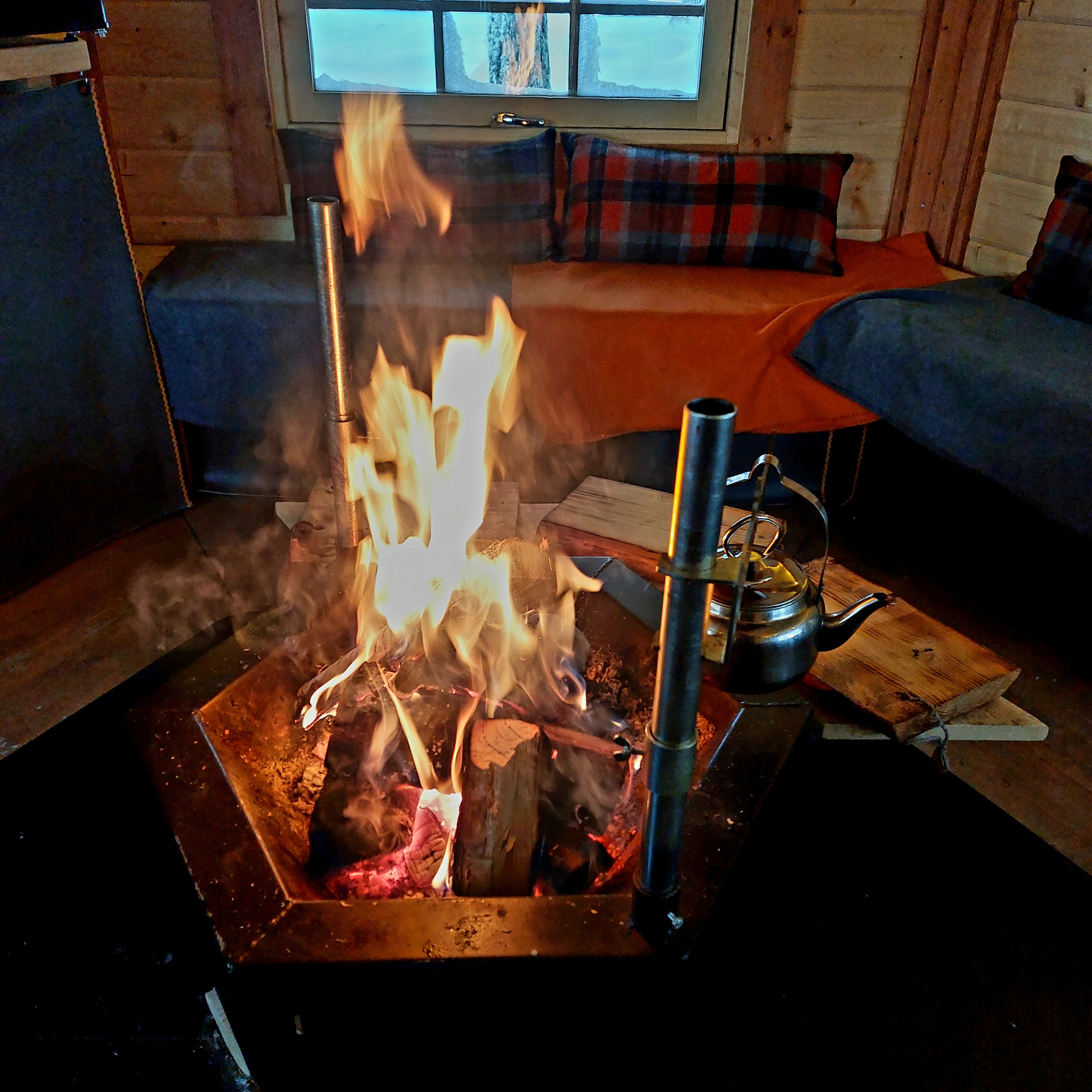 The open fire inside the kota with sausages grilling